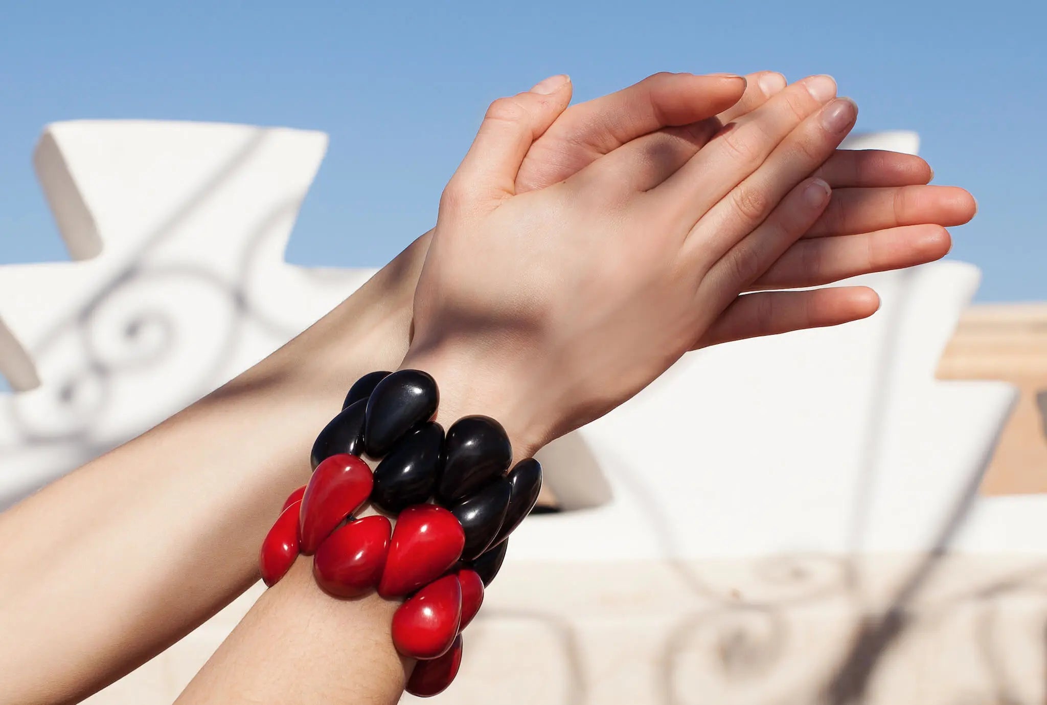 Frau trägt schwarze und rote Tagua Armbänder