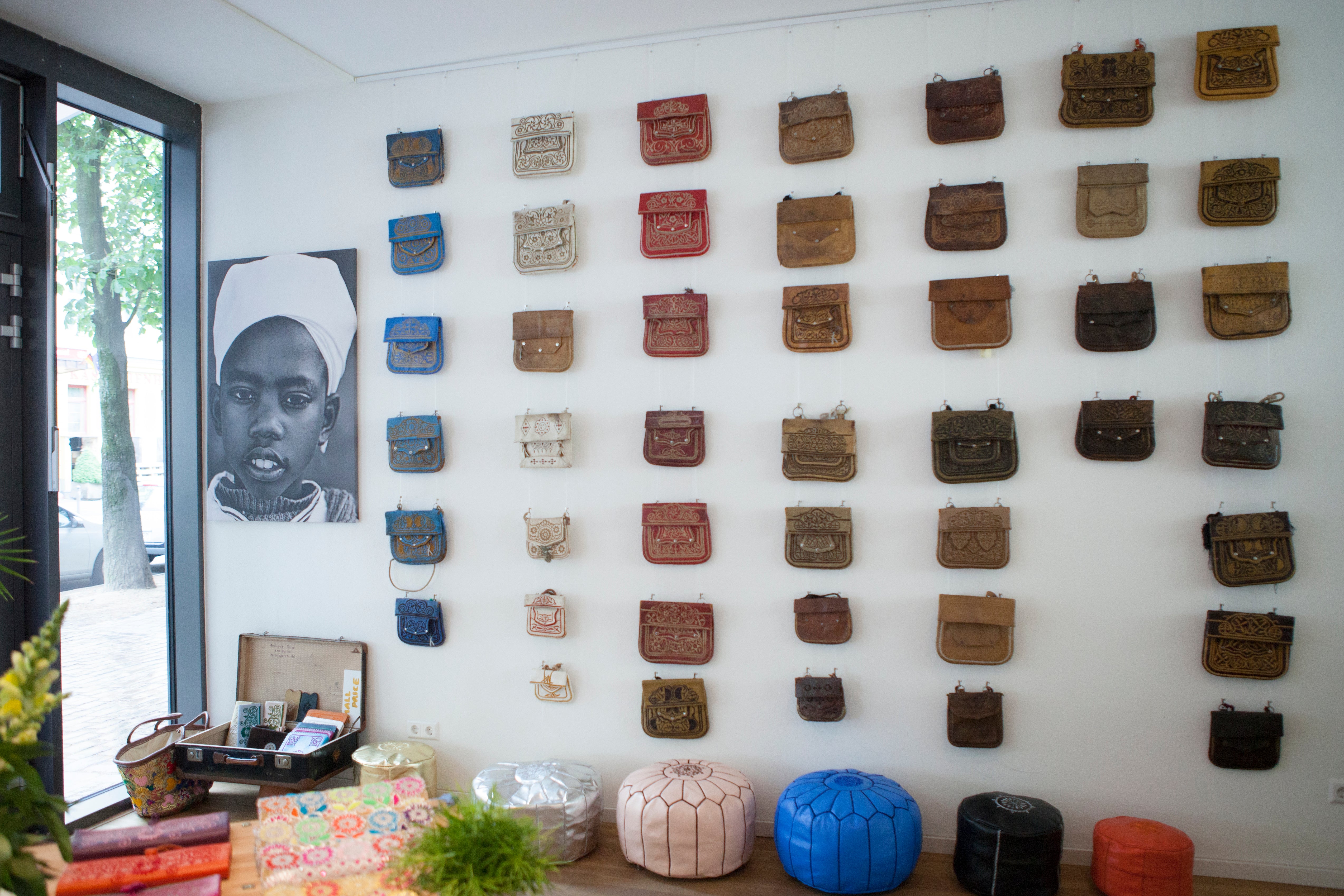 Bild aus dem ABURY Showroom: An der Wand hängen viele bestickte Berber-Taschen in unterschiedlichen Farben.