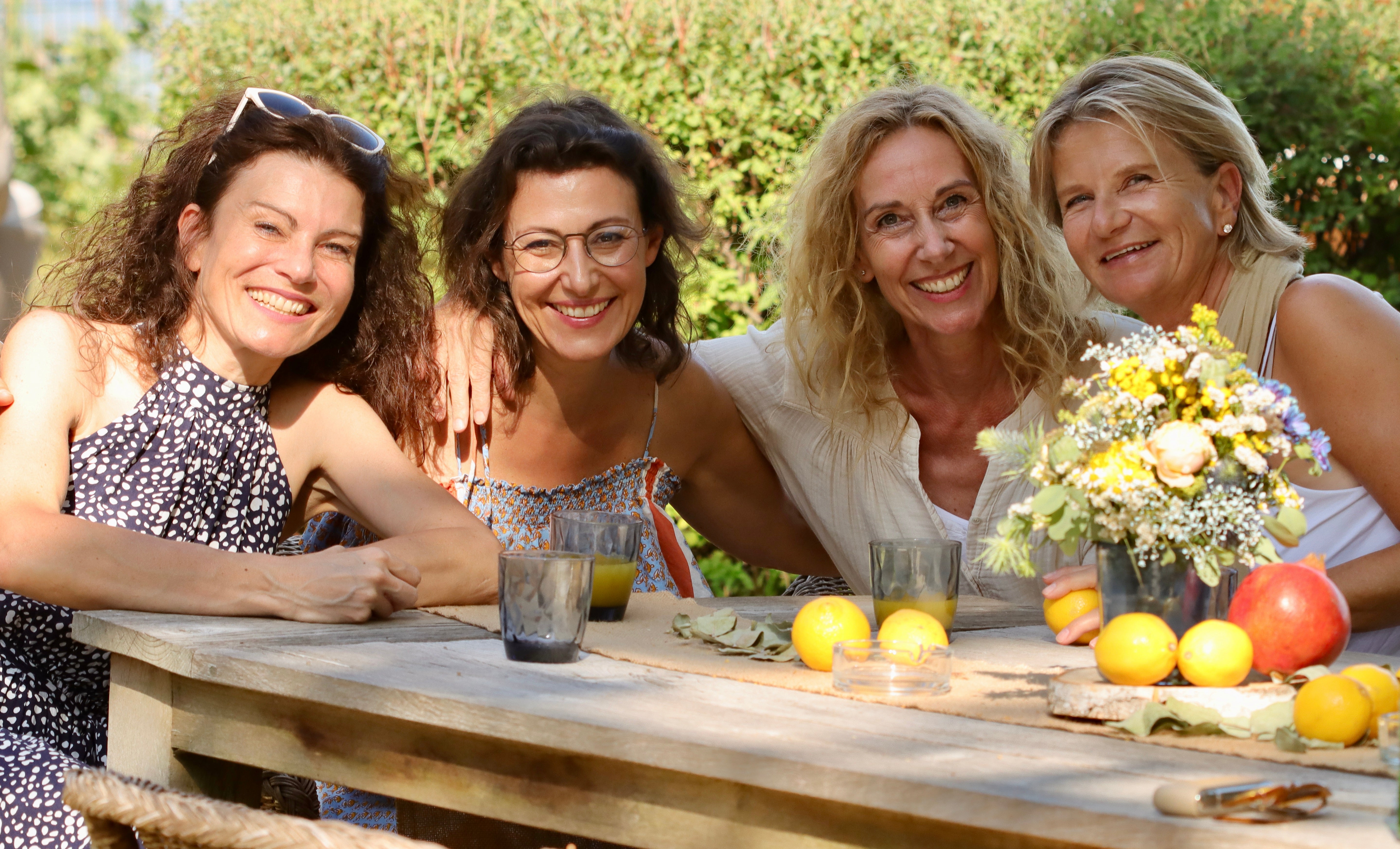 Vier Frauen, die Gesellschafterinnen von ABURY, sitzen gemeinsam an einem Tisch: Andrea, Heike, Britt und Petra.