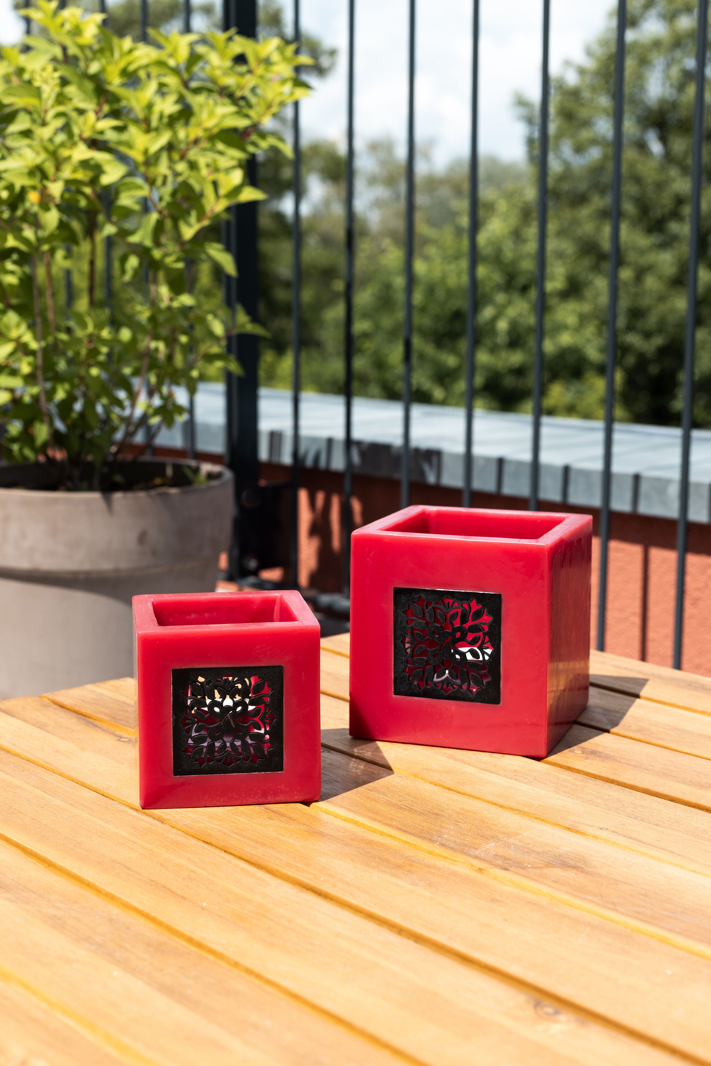 Zwei rote Windlichter auf einem Balkontisch #farbe_rot
