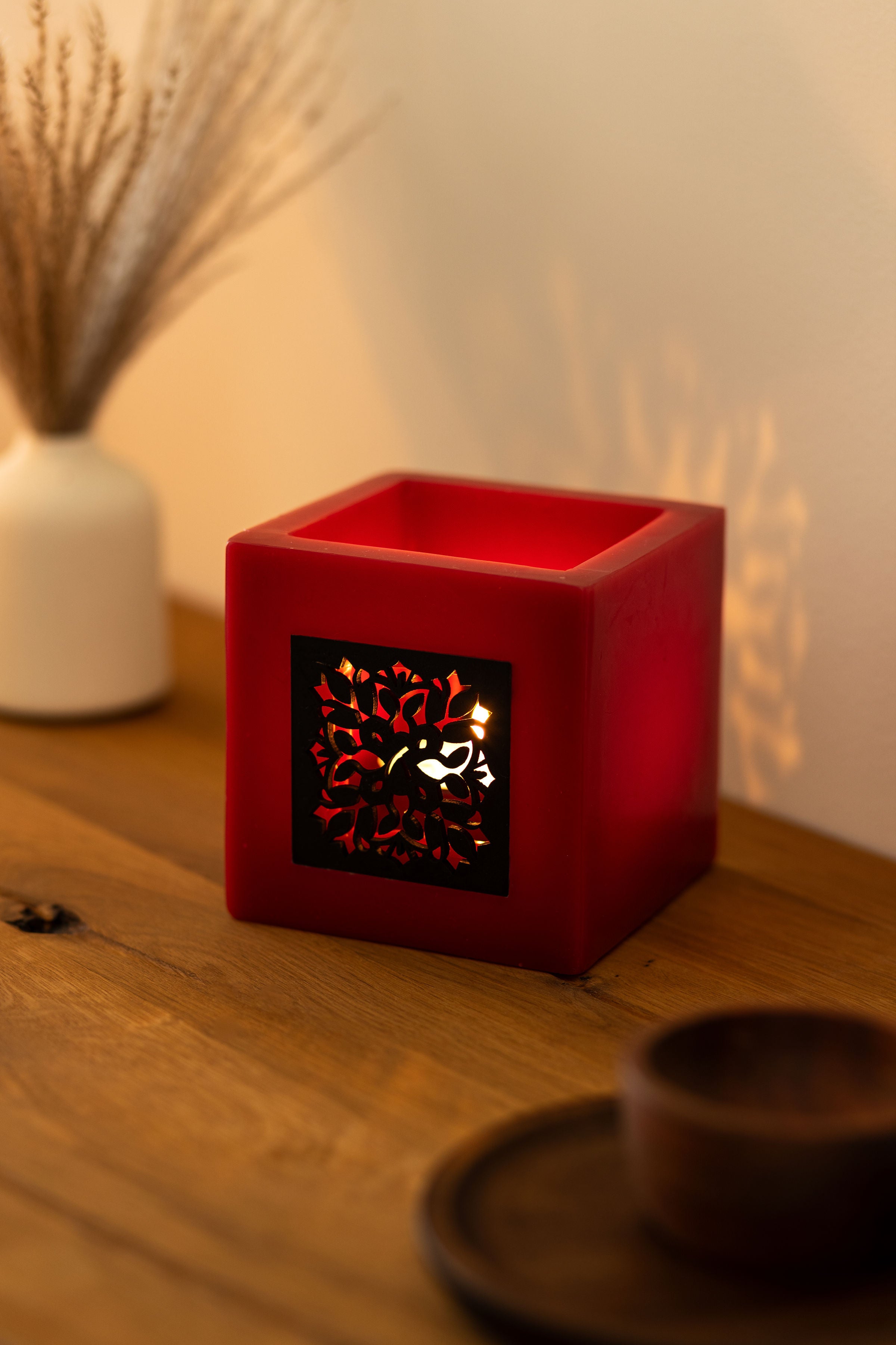 Rotes Windlicht auf einem Holzregal