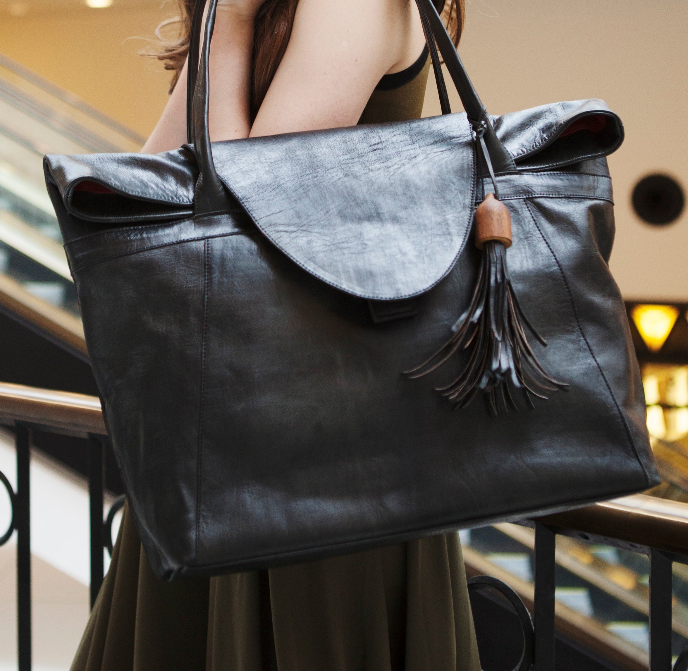 Frau trägt die schwarze ABURY Shopper Tasche aus Leder über der Schulter