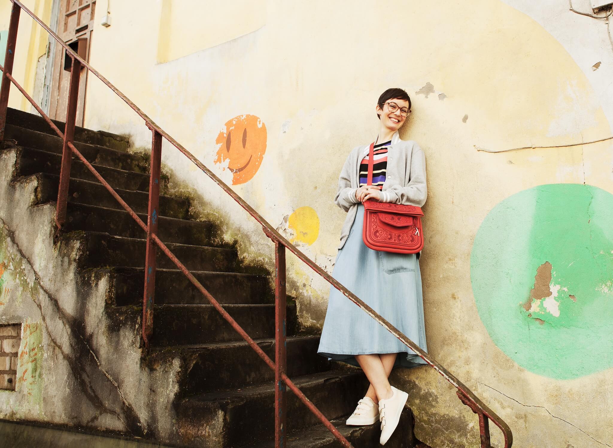 Frau mit roter ABURY Berber Bag auf einer Treppe #farbe_rot