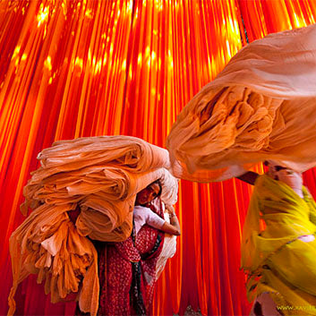 women carrying colourful textiles in india