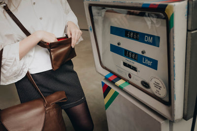 Die Frau posiert mit dem braunen ABURY-Shopper vor einer alten Tankstelle. #farbe_braun