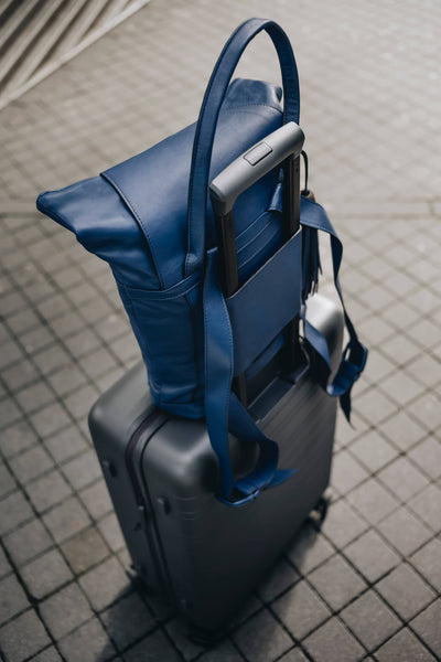 Ein blauer ABURY-Rucksack auf einem grauen Koffer. #farbe_blau