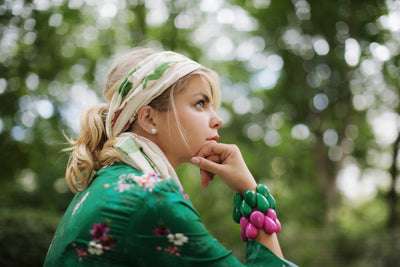 Frau trägt zwei Tagua-Armbänder, eines in Grün und eines in Pink. #farbe_pink #farbe_dunkelgruen