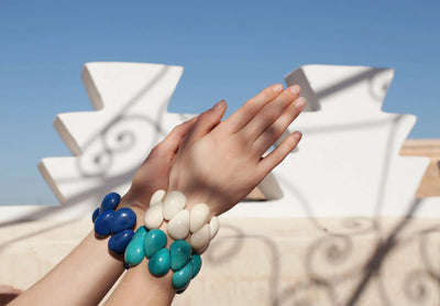 Frau trägt weiße und blaue Tagua Armbänder #farbe_blau #farbe_tuerkis