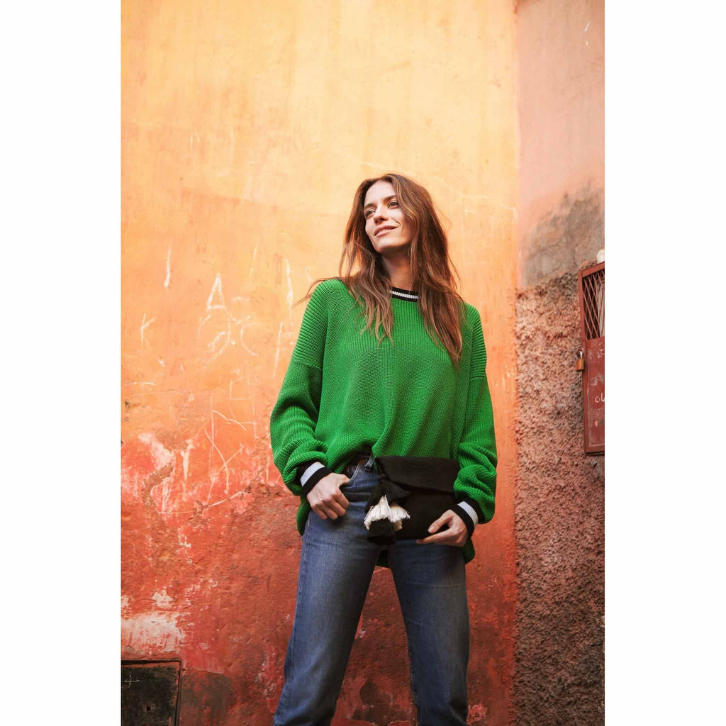 model with a green pullover wearing Black Cotton Clutch with Black and White Tassel