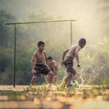 children playing football in nature