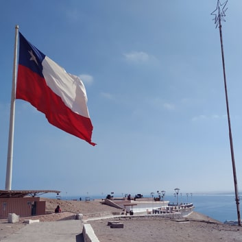 chilean flag on top of mountain with view on the harbour