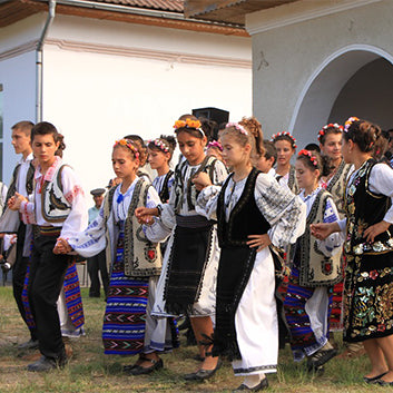 young romanians in traditional dress dancing